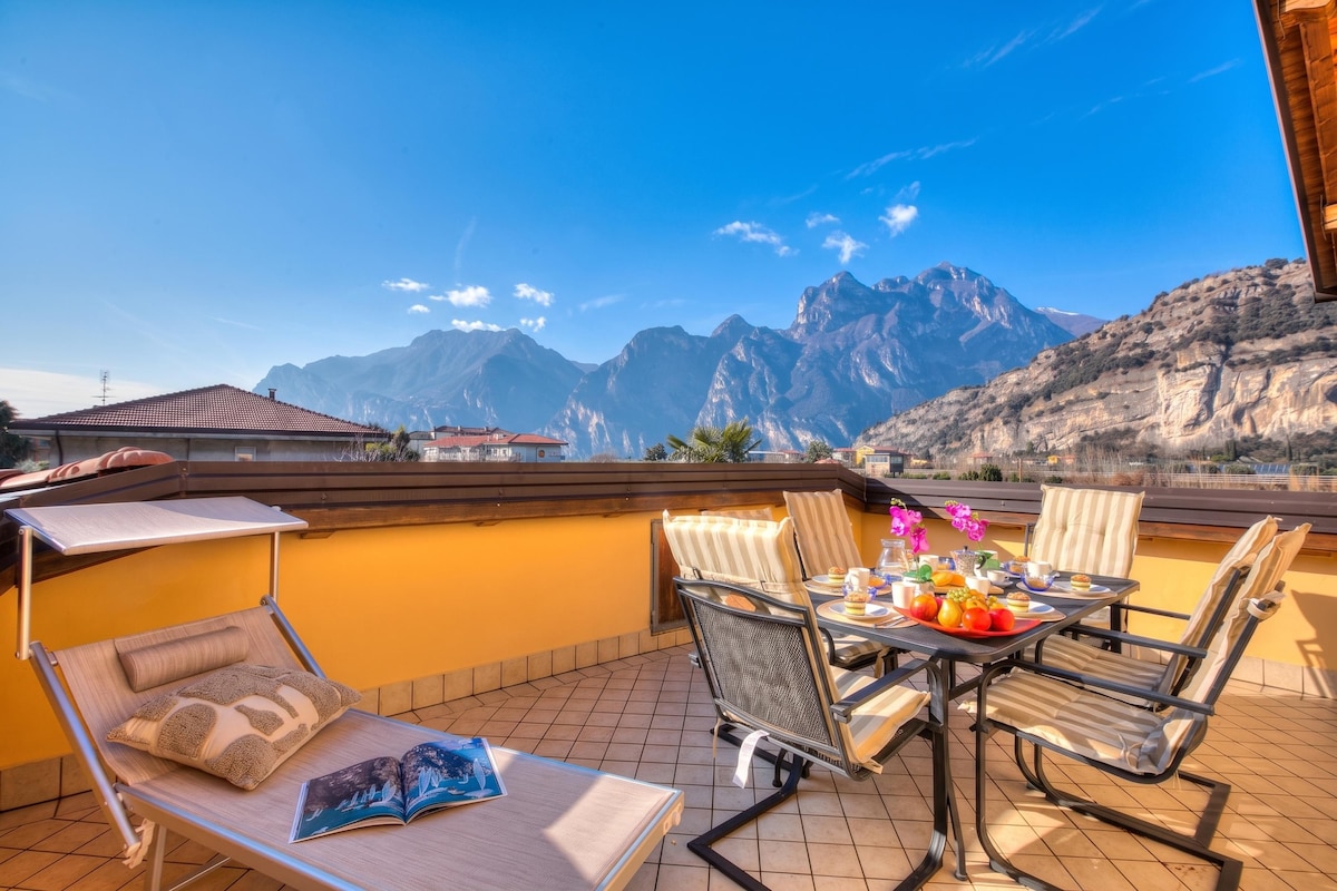 Eine Terrasse mit Frühstückstisch, mit Blick auf eine Berglandschaft.