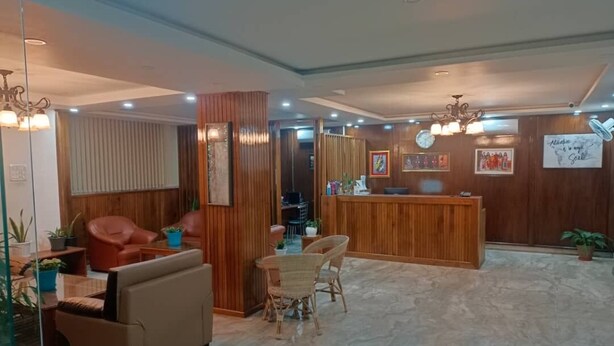 Un hall d’entrée avec un comptoir de réception, un espace salon et un lambris en bois.
