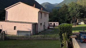 Un bâtiment à deux étages, doté d’un toit plat, entouré d’une cour verdoyante et d’une clôture.