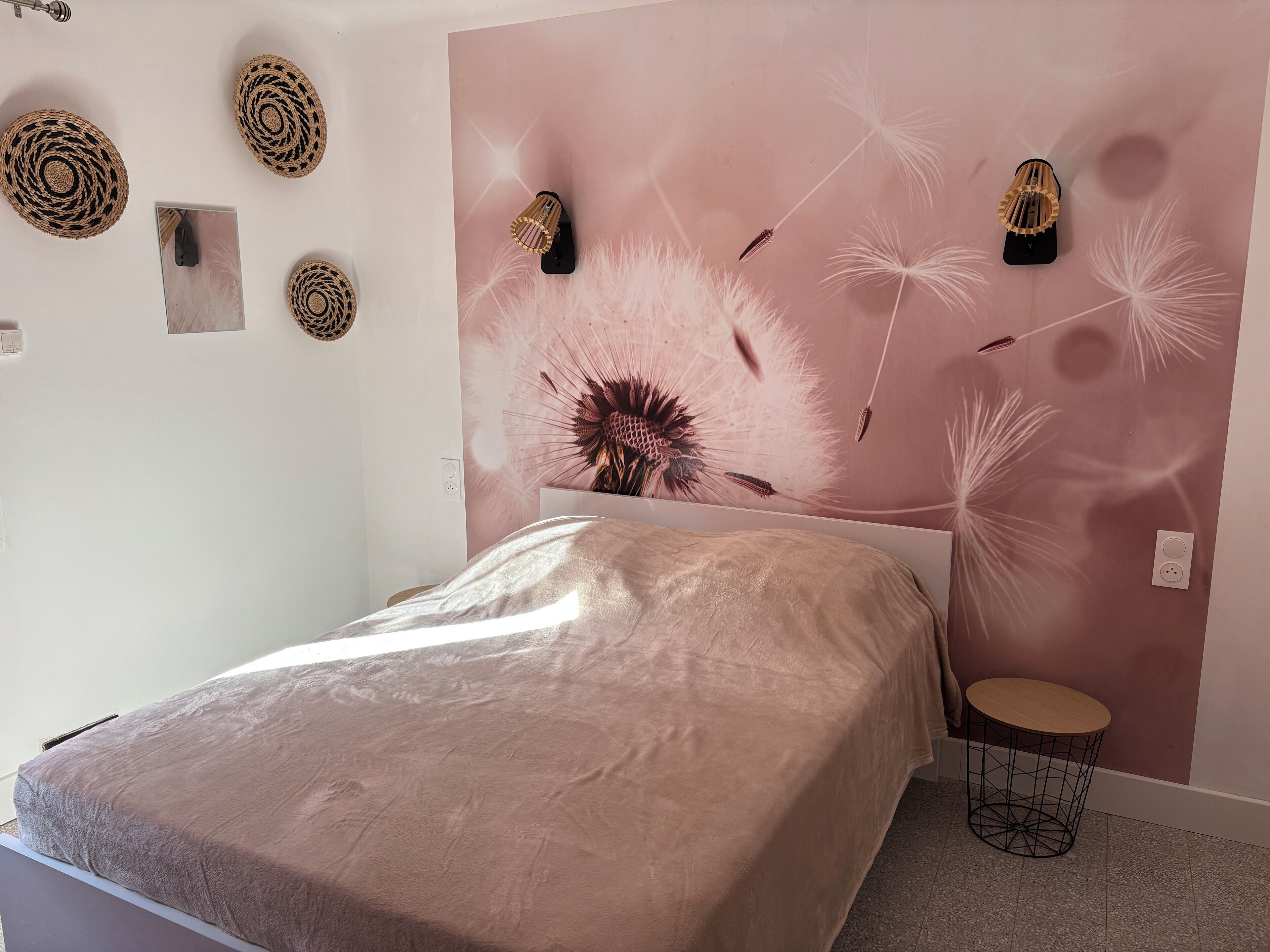 Ein Schlafzimmer mit einem Bett, einer Wandlampe und einer Wanddekoration.