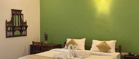 Un lit bien fait, agrémenté d’un coussin décoratif en forme de cygne, d’une tête de lit en bois et d’un mur vert.