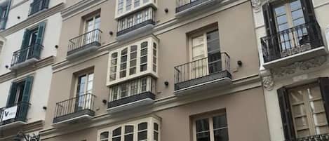 A multi-story building with balconies, large windows, and a classic architectural style.