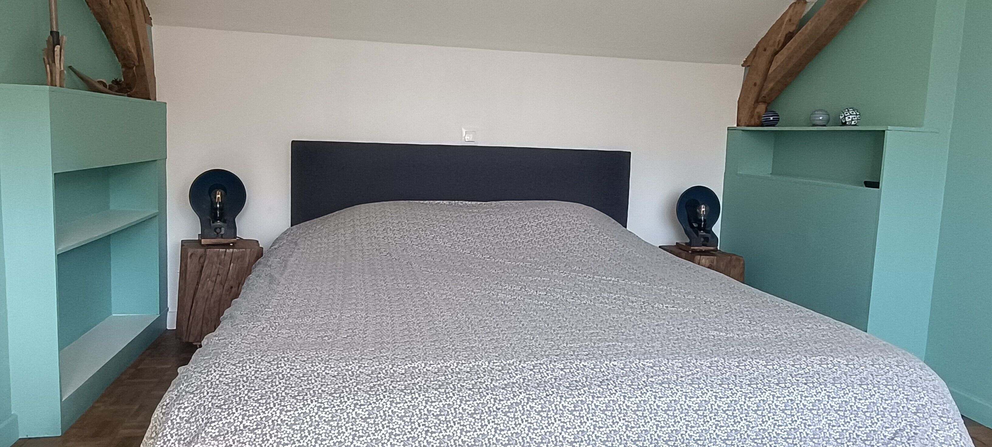 Un dormitorio con cama, mesitas de noche y estanterías.