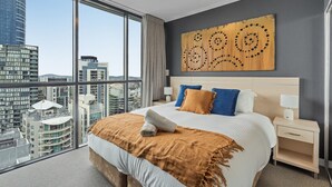 A modern hotel room with a large bed, a city view, and a unique wall art piece. - Bright 1-bed Retreat in Charlotte Towers (Brisbane)