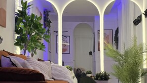 A modern living room with a brown sofa, a round coffee table, and a large potted plant. - Romantic cocoon & serenity 8 minutes from the Eiffel Tower (Paris)
