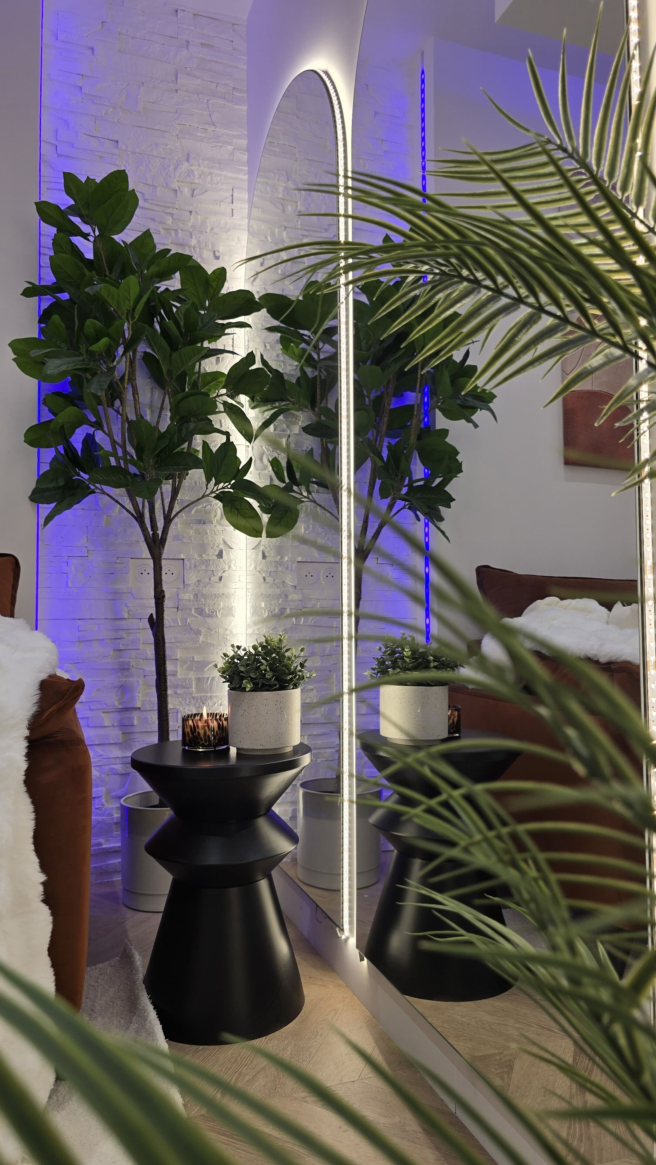 Un intérieur moderne avec un mur en briques, un miroir et des plantes en pot.