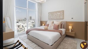 Un dormitorio moderno con un ventanal grande, una cama con varias almohadas, una mesita de noche con lámpara y una obra de arte en la pared.