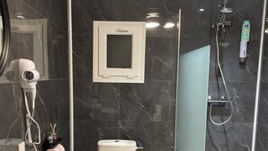A modern bathroom with a white sink, toilet, and shower. - Spacious detached apartment in quiet area (Allouagne)