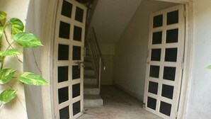 Un couloir étroit avec un escalier menant à l’étage supérieur.