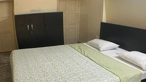Une chambre d’hôtel avec un lit, une armoire et une porte.