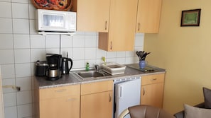 A kitchen with a microwave, coffee maker, sink, and cabinets. - Lissis Apartment in Karlshagen (Karlshagen)