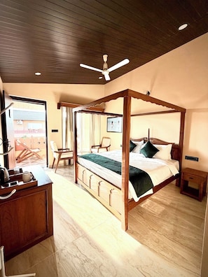 Una cama con dosel de madera, un ventilador de techo y una mesita de noche.