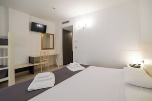 Habitación cuádruple Confort, para no fumadores | Escritorio y ropa de cama