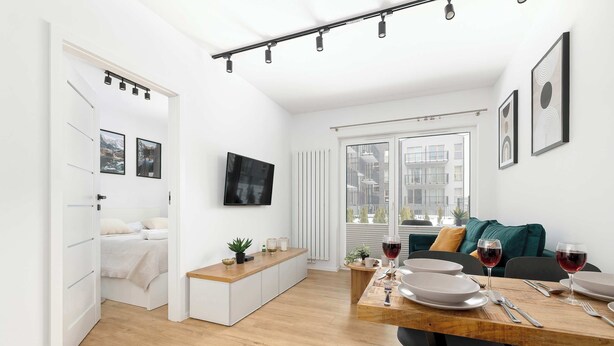 Un apartamento moderno con comedor, kitchenette, cama y televisor.