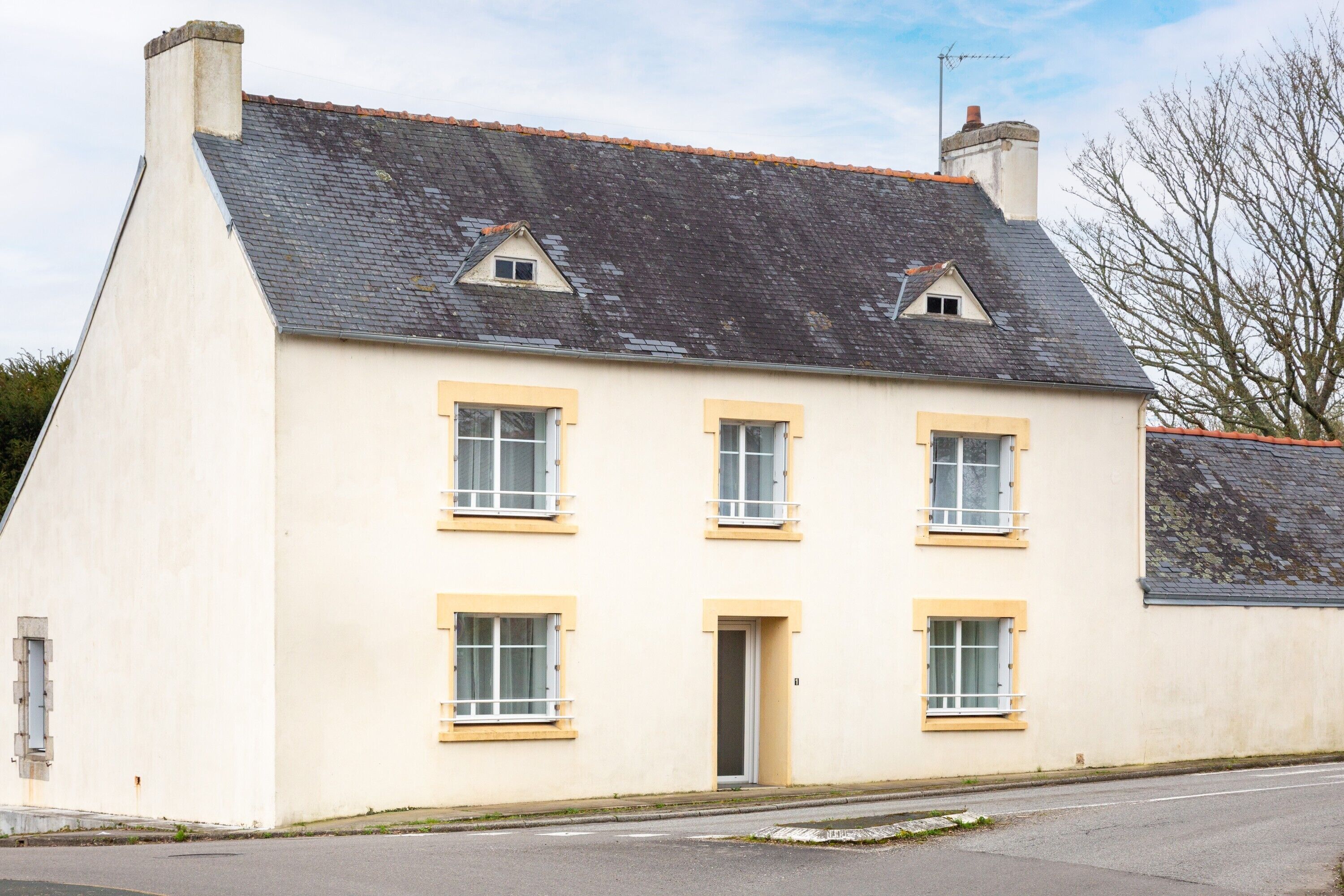 Un bâtiment à deux étages, doté d’un toit plat, de nombreuses fenêtres et d’une porte.