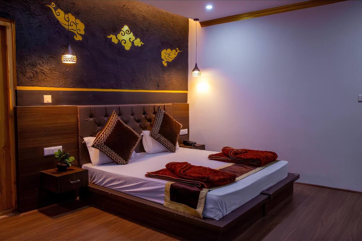 Een moderne slaapkamer met een groot bed, een houten hoofdeinde en decoratieve muurdecoratie.