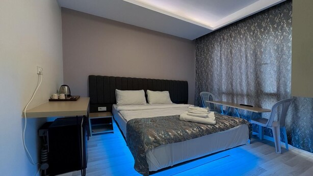 Ein modernes Hotelzimmer mit einem großen Bett, einem Schreibtisch und einem Sessel.