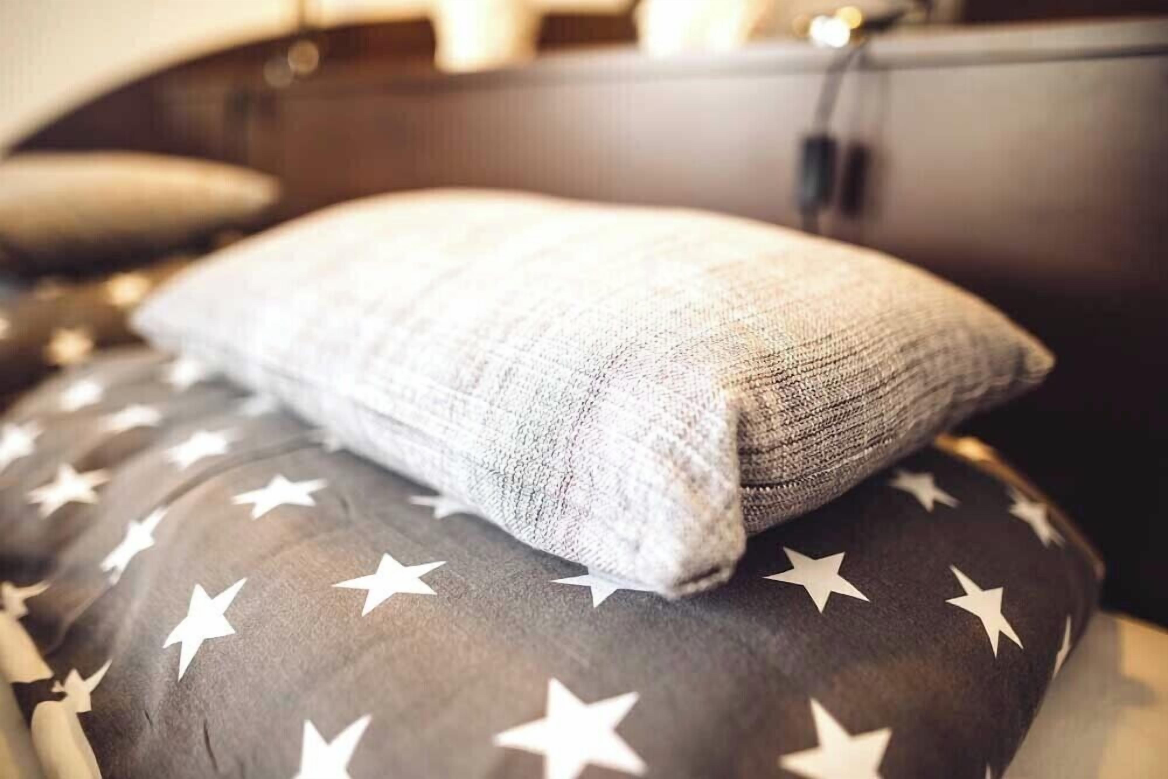 A pillow with a star pattern on a couch.