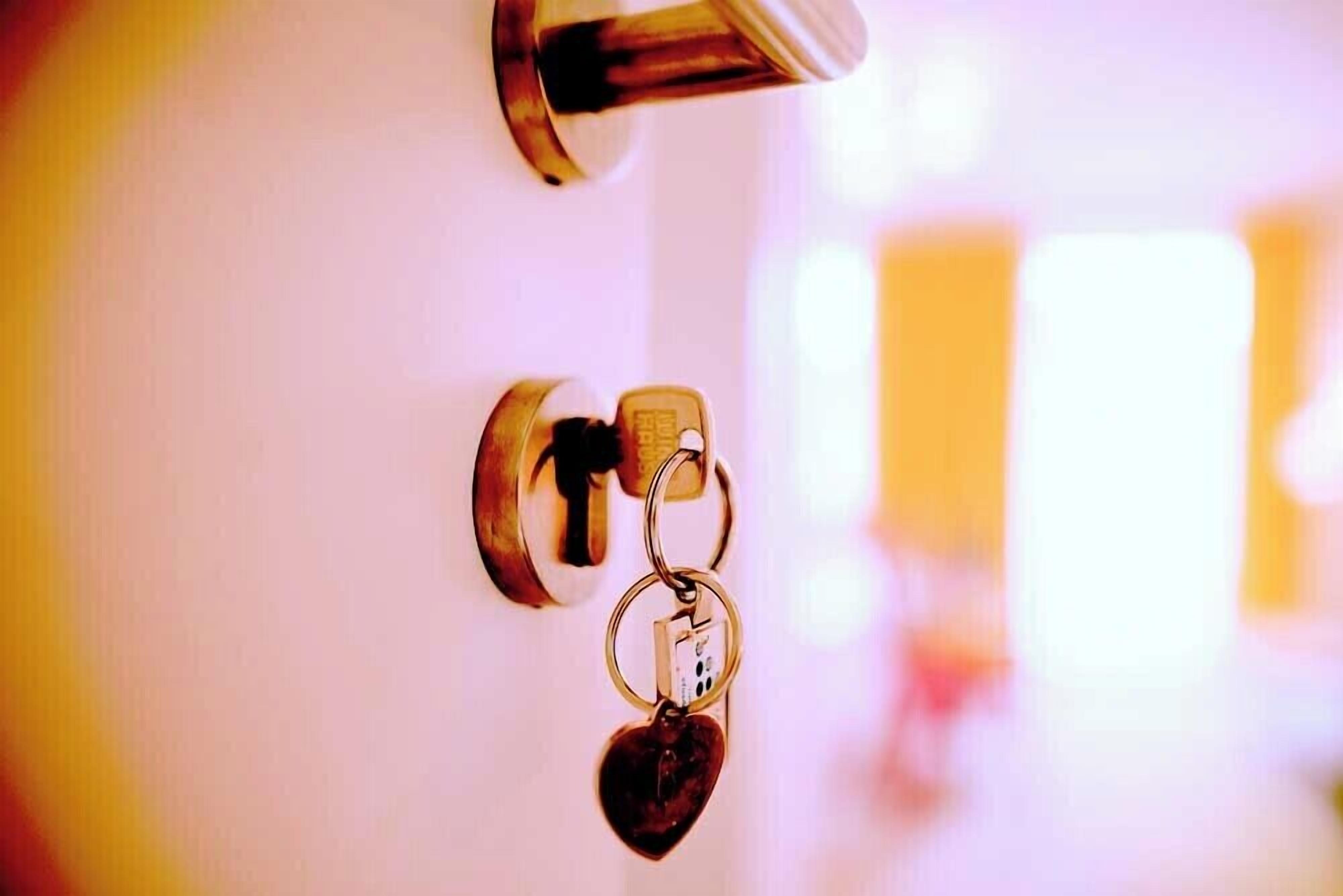 A door with a keyhole and a keychain with a heart-shaped key.