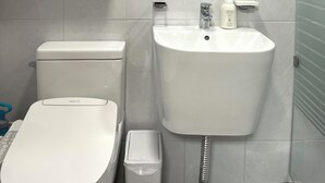 Une salle de bain moderne avec des toilettes, un lavabo et un miroir.