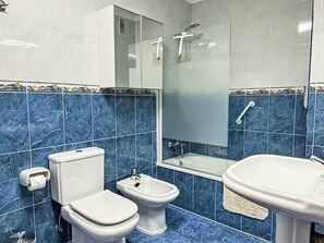 A bathroom with a toilet, bidet, and sink, all in white, with blue marble tiles on the walls. - mit Aussicht in Luanco by Interhome (Luanco)