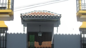 A building with a tiled roof, a black gate, and a lantern above the entrance. - "Remedios" mit Terrasse by Interhome (Cuevas del Becerro)