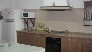 A kitchen with a microwave, stove, and cabinets. - "Remedios" mit Terrasse by Interhome (Cuevas del Becerro)