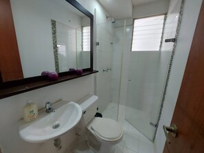 A bathroom with a white sink, toilet, and glass shower enclosure. - South of Cali Quiet Modern (Cali)