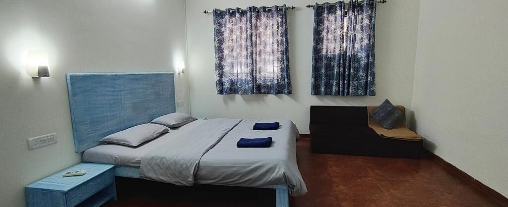 Une chambre à coucher avec un lit, une table de chevet et un banc avec des coussins.