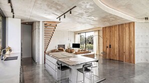 Eine moderne Küche mit Kochinsel, Barhocker und Kamin.