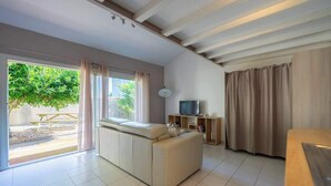 Una sala de estar moderna con un sofá, televisión y una zona de comedor.