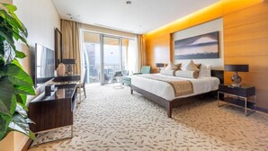 A modern hotel room with a large bed, a flat-screen TV, a desk, and a balcony with a view. - Emaar Fashion Avenue Residences  (Dubai)