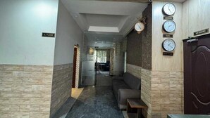 A hallway with a bench, clocks displaying London, Paris, and New York times, and a 'No Entry' sign. - Townhouse Ludhiana Railway Junction (Ludhiana)