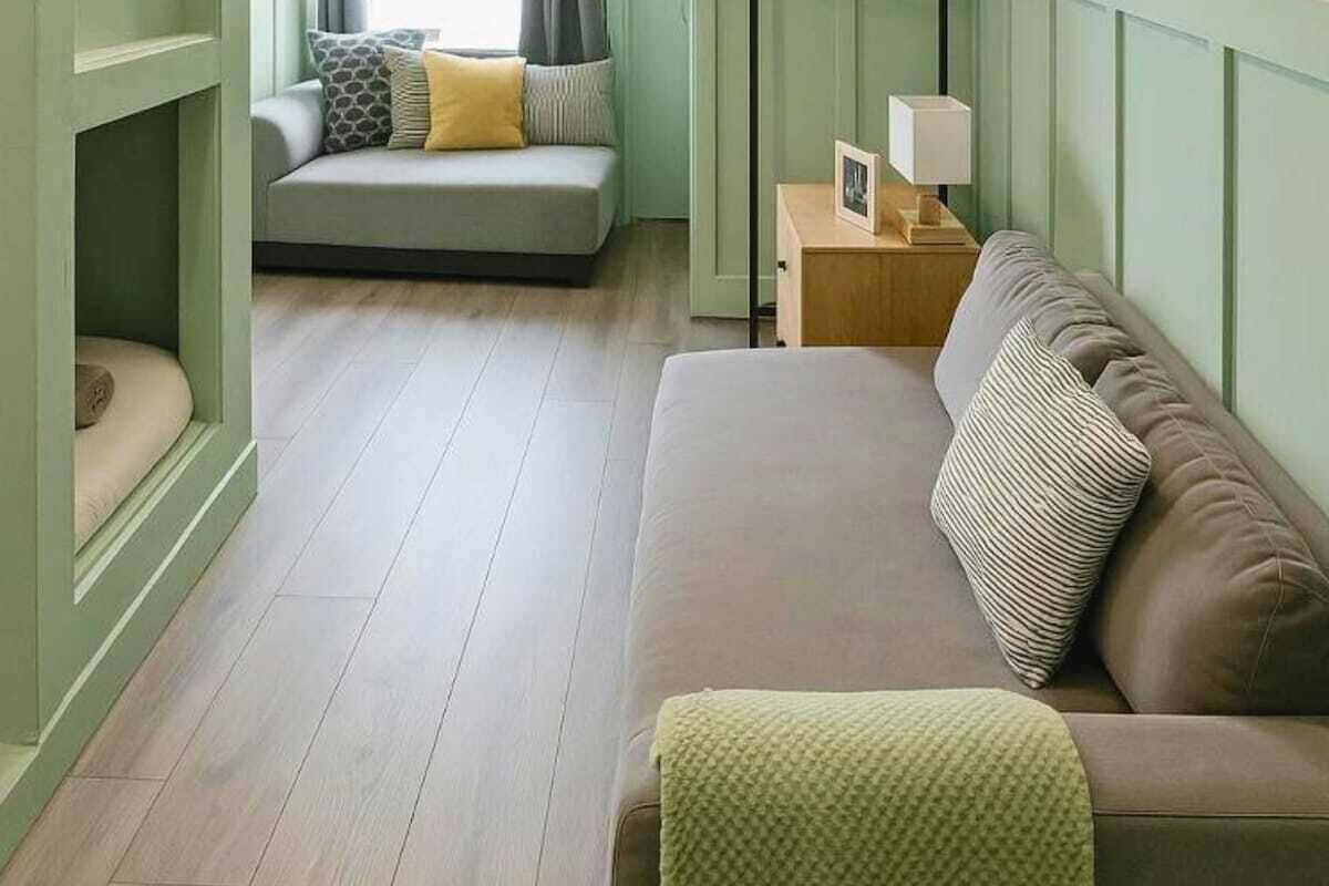 Une pièce comprenant un canapé, une petite table avec une lampe et un banc rembourré.