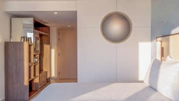 Un dormitorio con una cama grande, un armario, un espejo y un adorno circular en la pared.