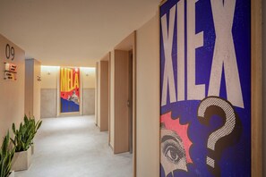A hallway with doors, a number '09' sign, and a large 'MEL' sign with a building illustration. - Innside By Meliá Bugibba (St. Paul's Bay)