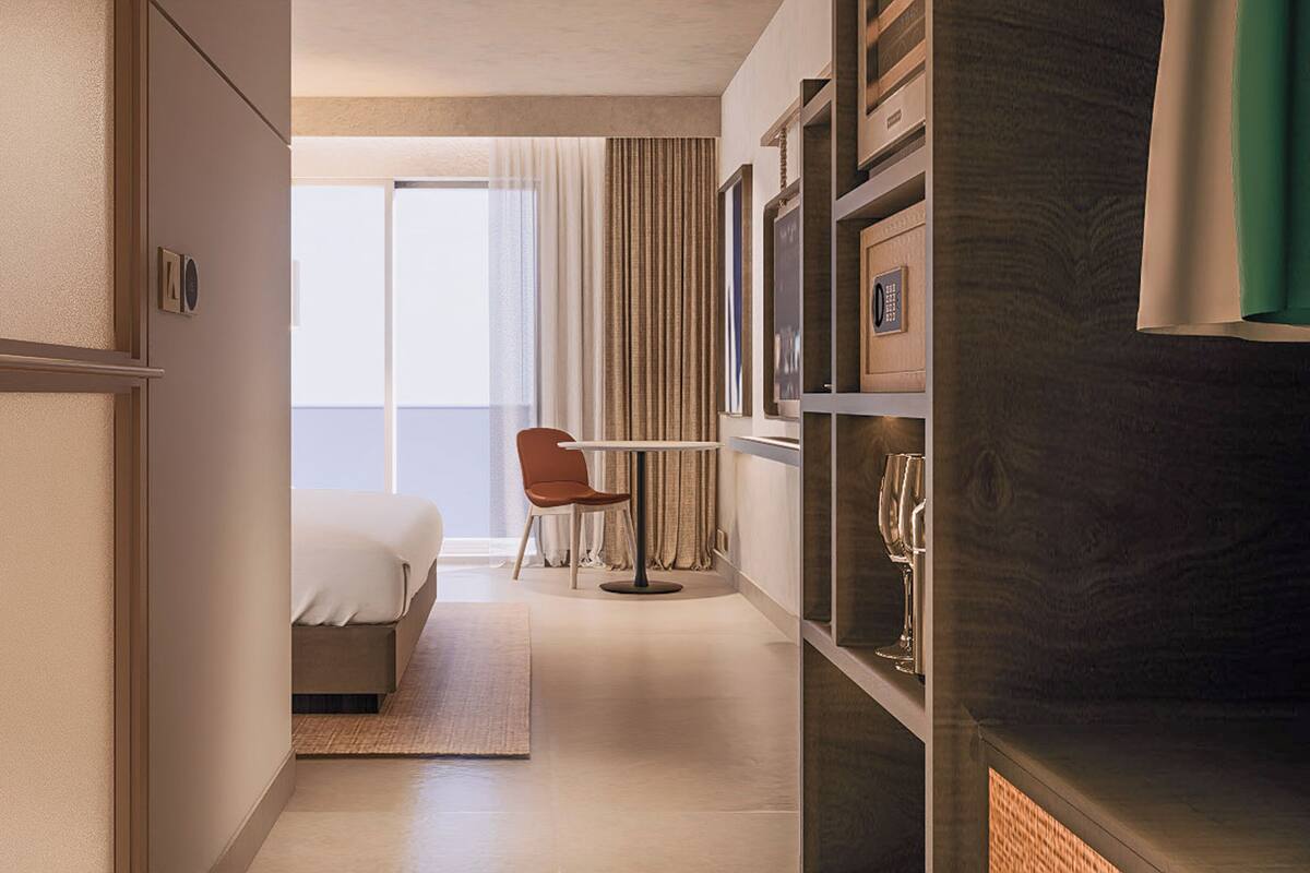 Une chambre d’hôtel avec un lit, une chaise, un bureau et une bibliothèque.