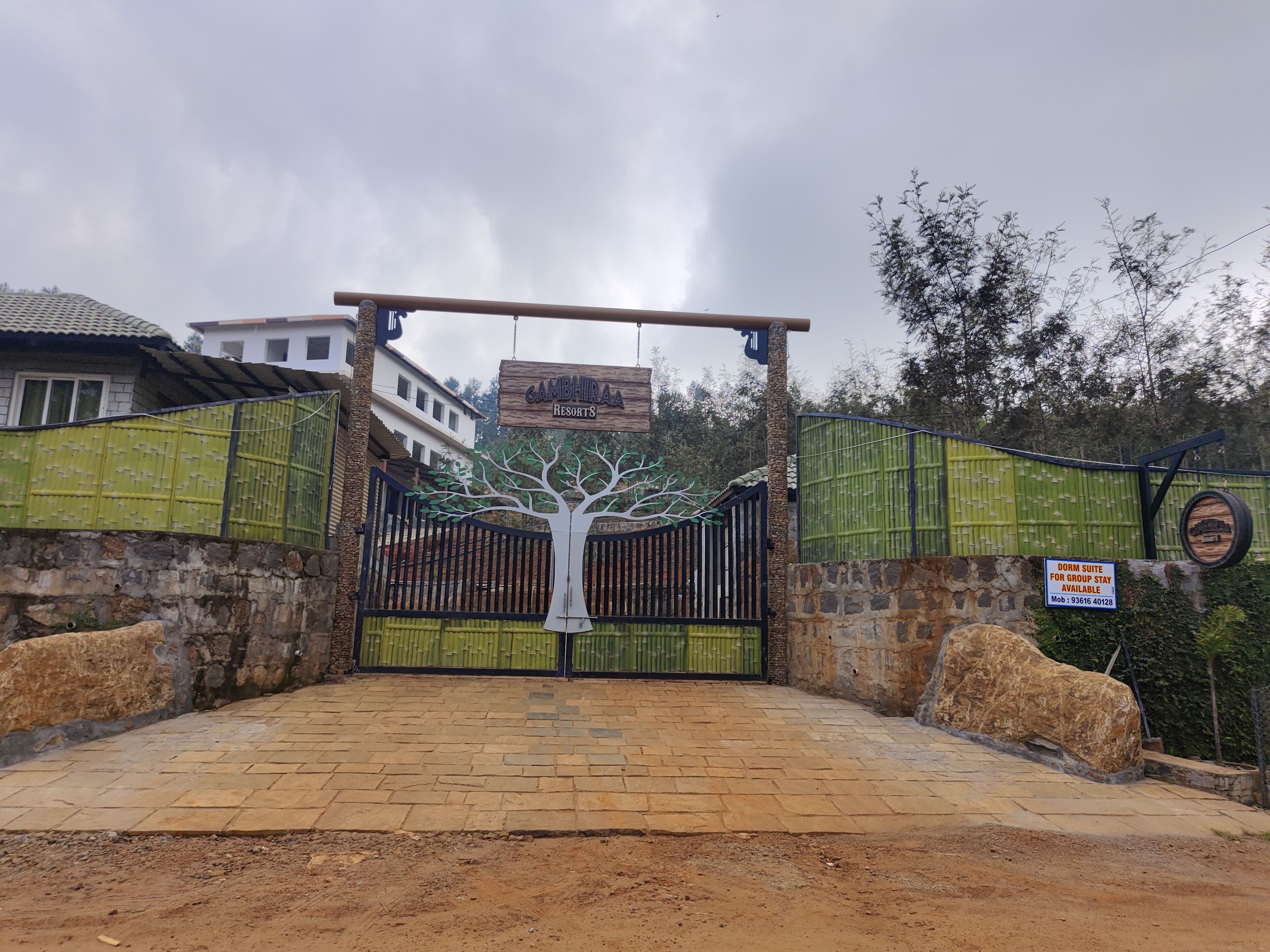 A gated entrance to Gambhiraa Resorts with a sign indicating a dormitory for group stays.