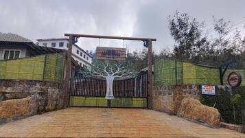 A gated entrance to Gambhiraa Resorts with a sign indicating a dormitory for group stays.