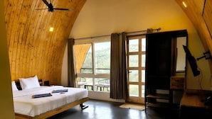 A bedroom with a bed, a desk, and a view of the outdoors. - Gambhiraa Resorts (Kolli Hills)
