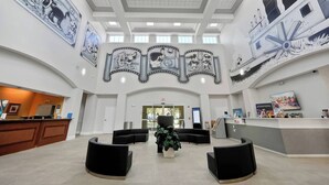 En rummelig lobby med en receptionsdisk, sorte siddepladser og store vægmalerier af Mickey Mouse.