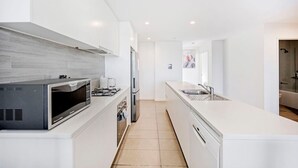 Una cucina moderna con forno a microonde, piano cottura e frigorifero integrati.