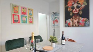 Ein Esstisch, gedeckt mit Weingläsern, einer Champagnerflasche und einer Fernbedienung.