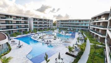 Un resort con piscina central, varios balcones y zonas de estar al aire libre.