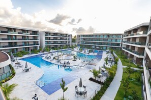 Resort com piscina central, várias varandas e áreas de estar ao ar livre.