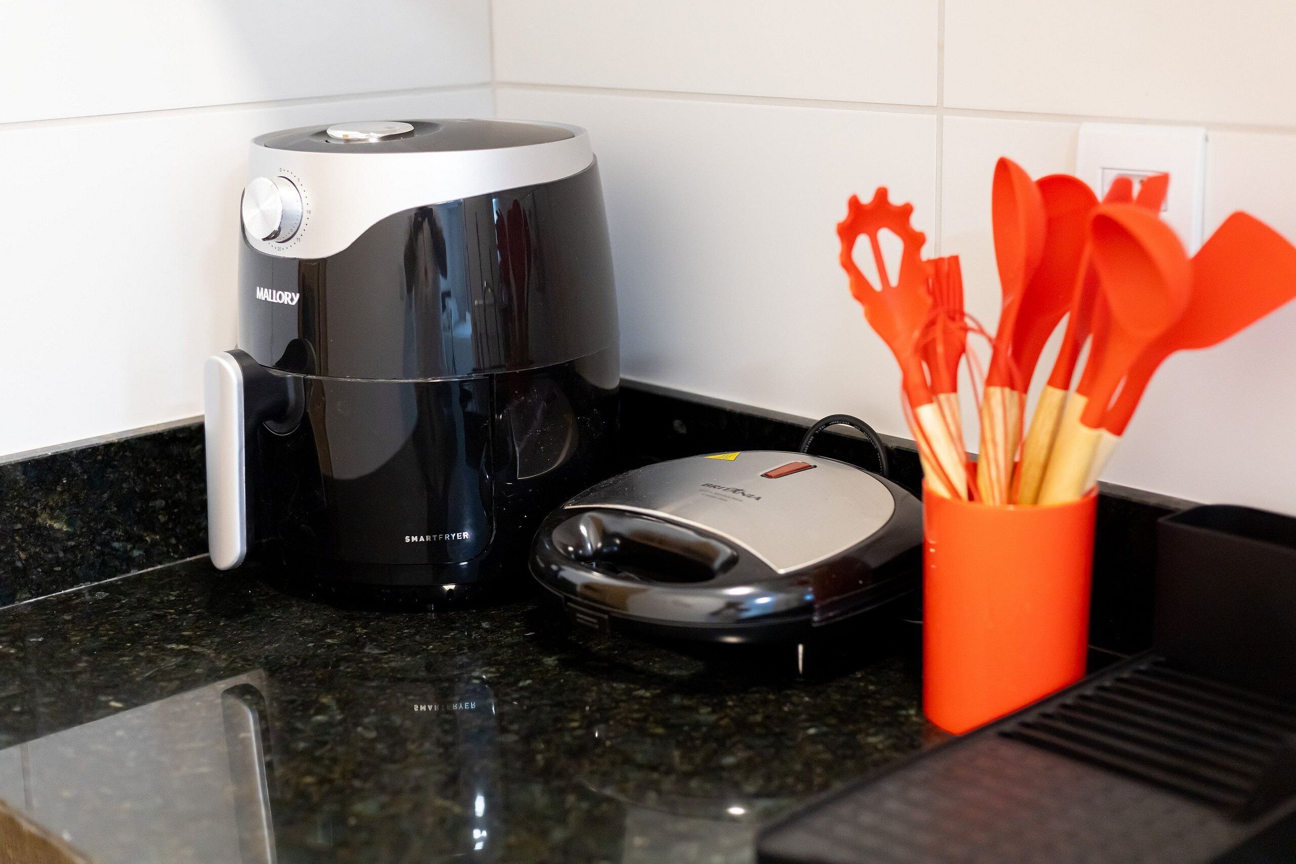 A kitchen with a coffee maker, a toaster, and a utensil holder.