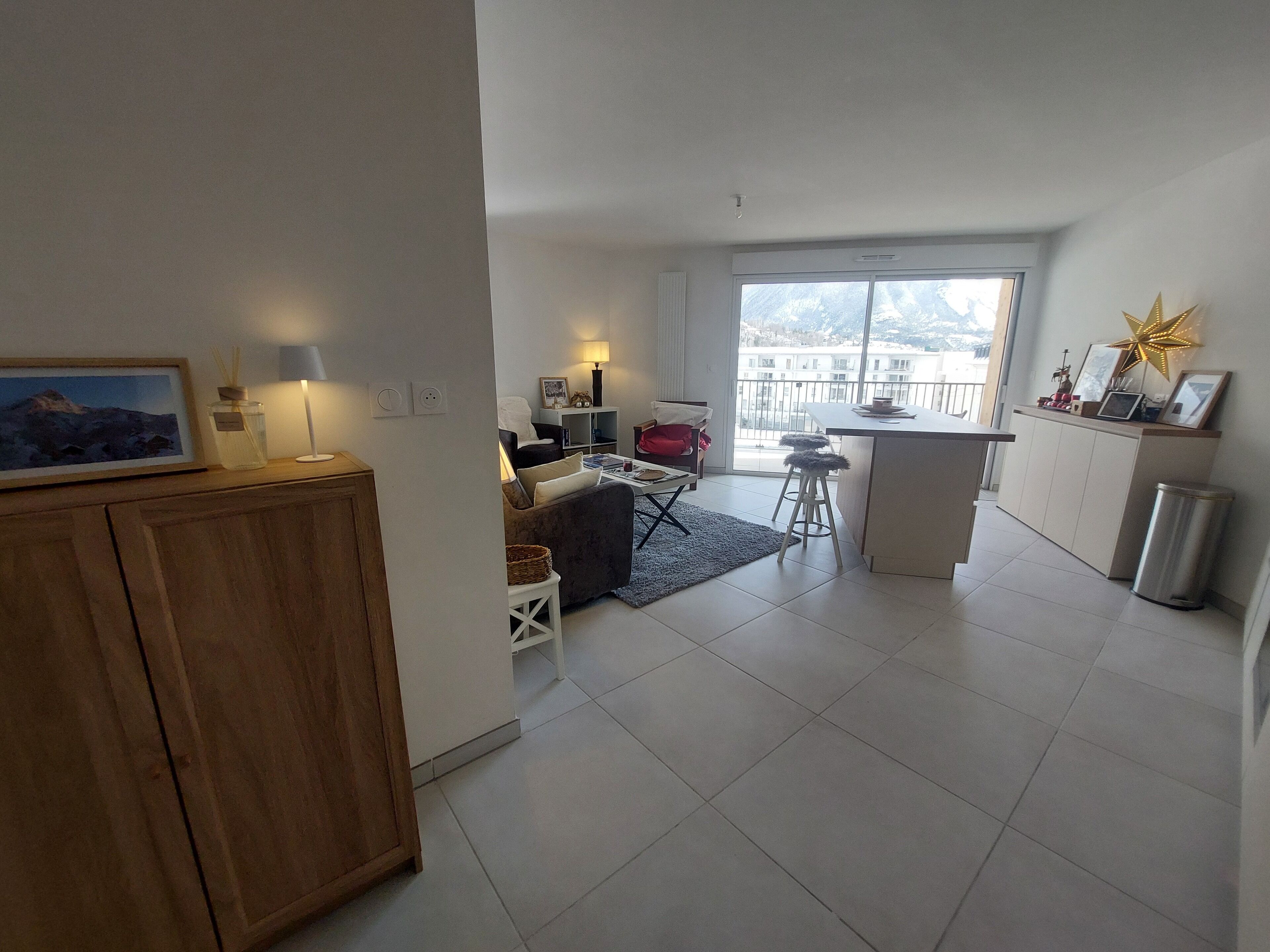 Eine moderne Wohnung mit Wohnbereich, Küche und Balkon.