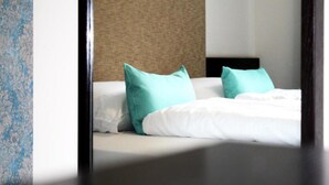 A hotel room with a bed, two pillows, a headboard, and a textured wall. - Koblenz Valley Hotel Double Room Extra Bed (Bendorf)