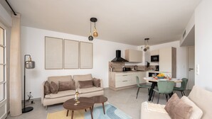 En moderne stue med sofa, sofabord og spiseplads.