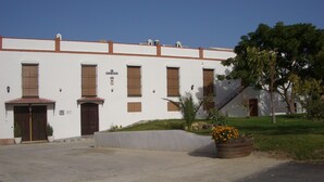 Un edificio con fachada blanca, varias ventanas y un letrero que dice 'Patriarcal'.